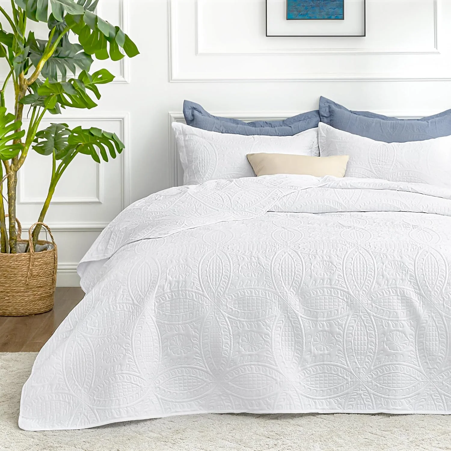 White coin pattern quilt spread over a queen bed